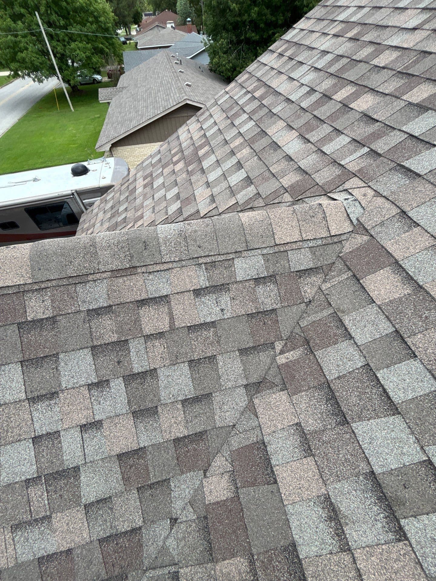 Close-up of granule loss from hail impact showing exposed asphalt layer