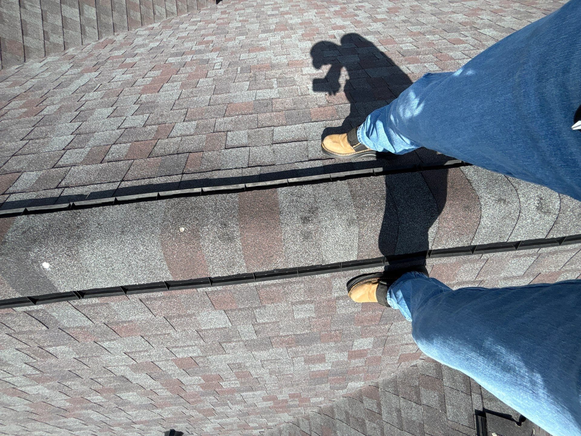 Professional roof inspector examining hail damage on residential roof