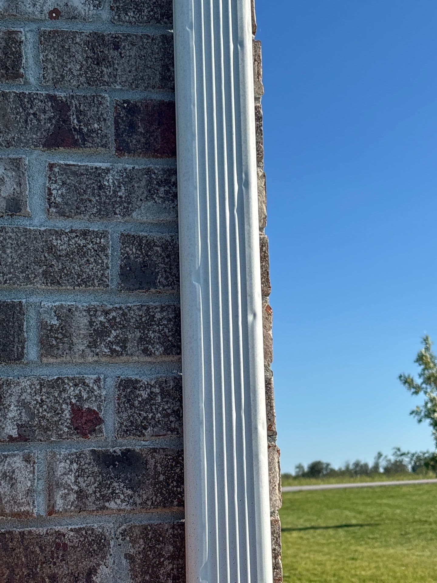 Close-up view of hail damage on asphalt shingles showing granule loss